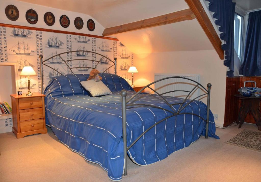 a bed with a blue comforter in a bedroom at Captains Cabin in Whitby