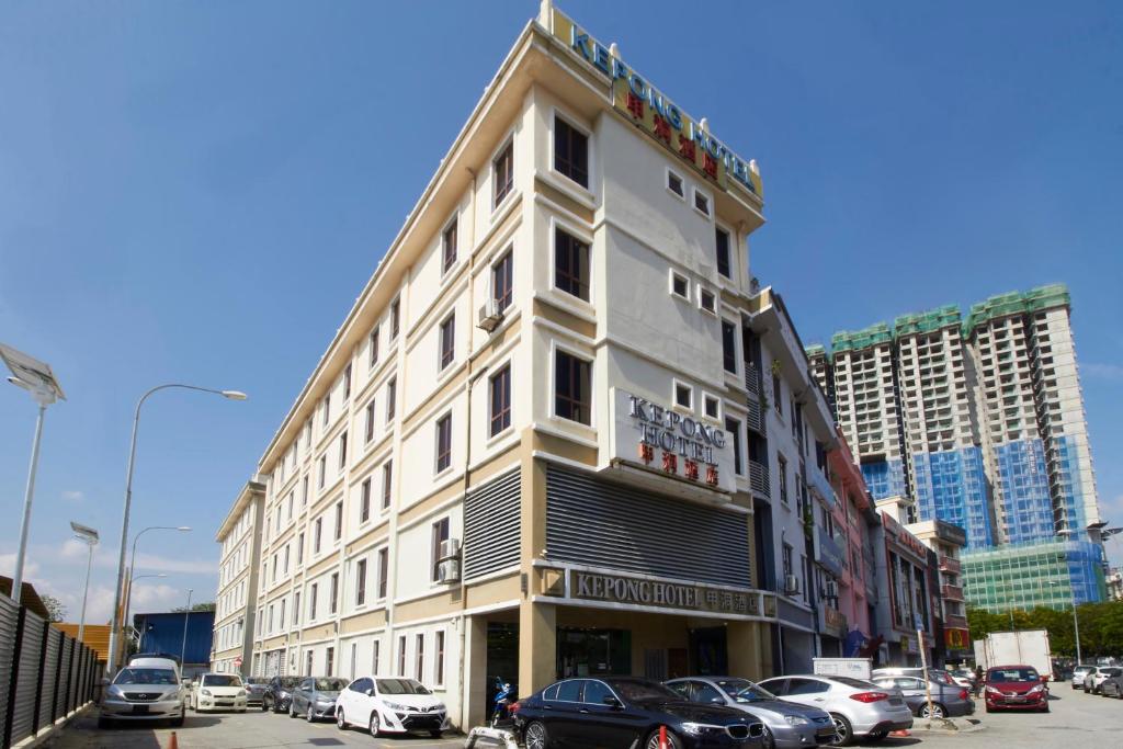 un edificio blanco con coches estacionados en un estacionamiento en Kepong Hotel en Kuala Lumpur