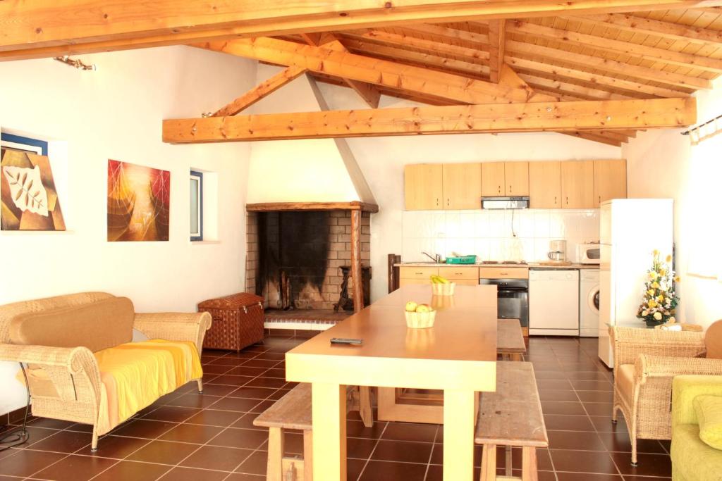 Una sala de estar con una mesa y una cocina. en Charming House in Burinhosa, Pataias with Shared Pool, en Burinhosa