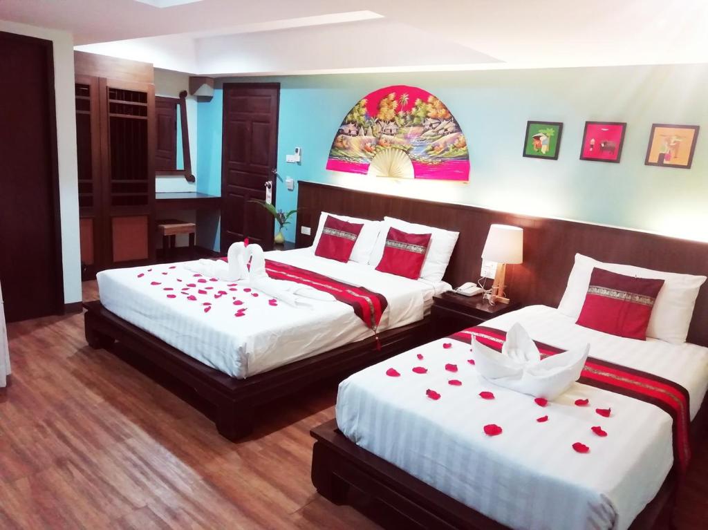 a bedroom with two beds with red roses on them at Mandala House, Chiang Mai in Chiang Mai