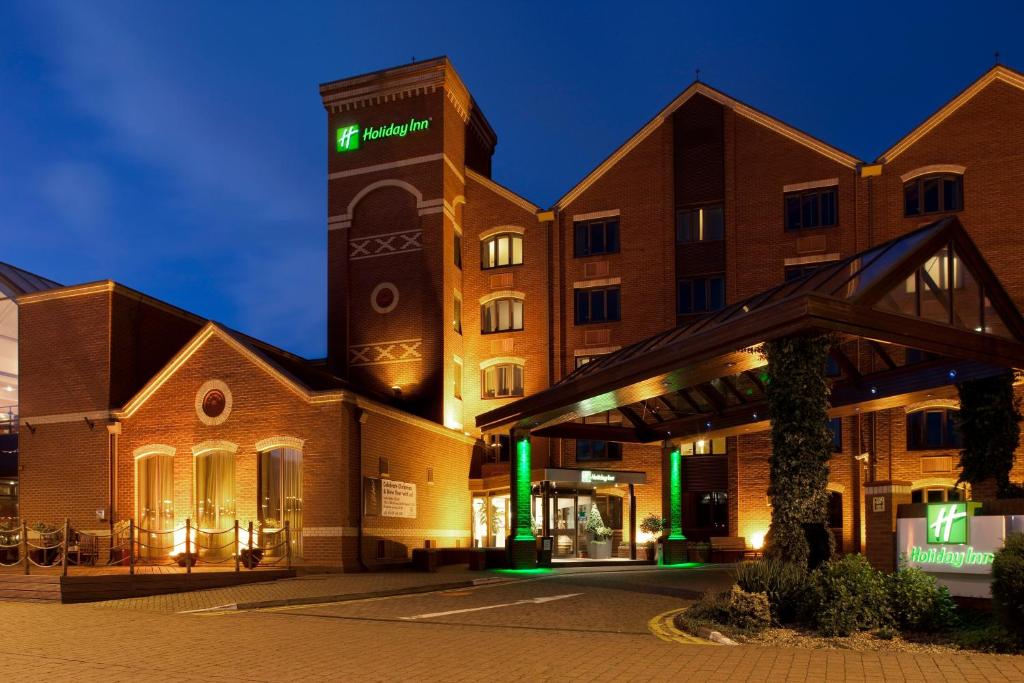 un edificio con una torre dell'orologio di notte di Holiday Inn Lincoln, an IHG Hotel a Lincoln