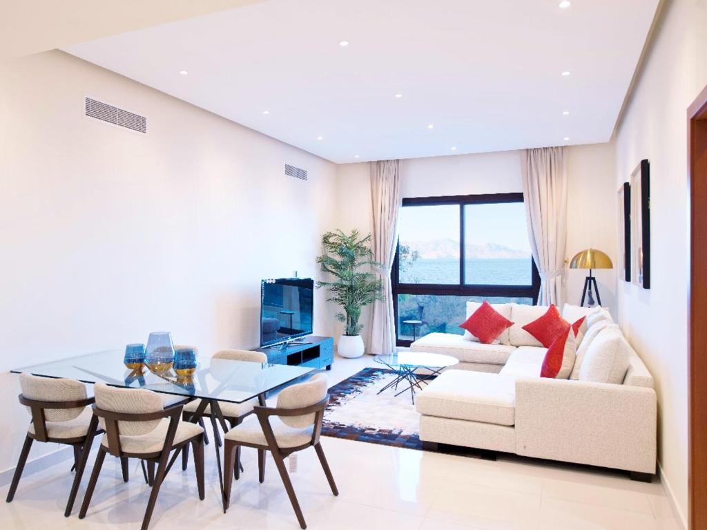 a living room with a white couch and a table at Apartment 004 - Mina Al Fajer in Fujairah