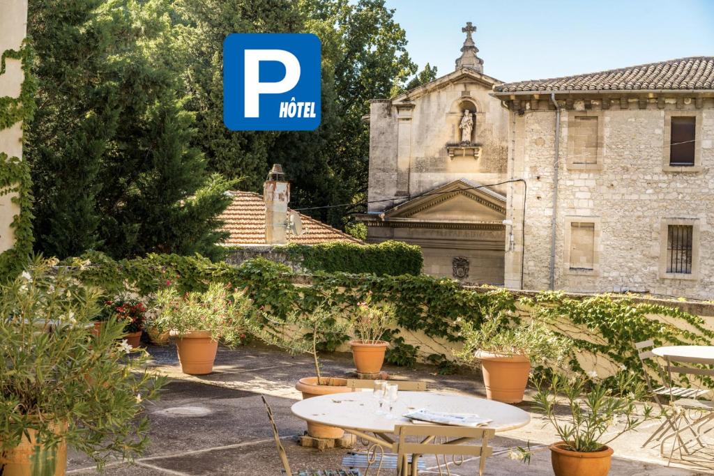 a patio with two tables in front of a building at Hotel d'Angleterre in Avignon