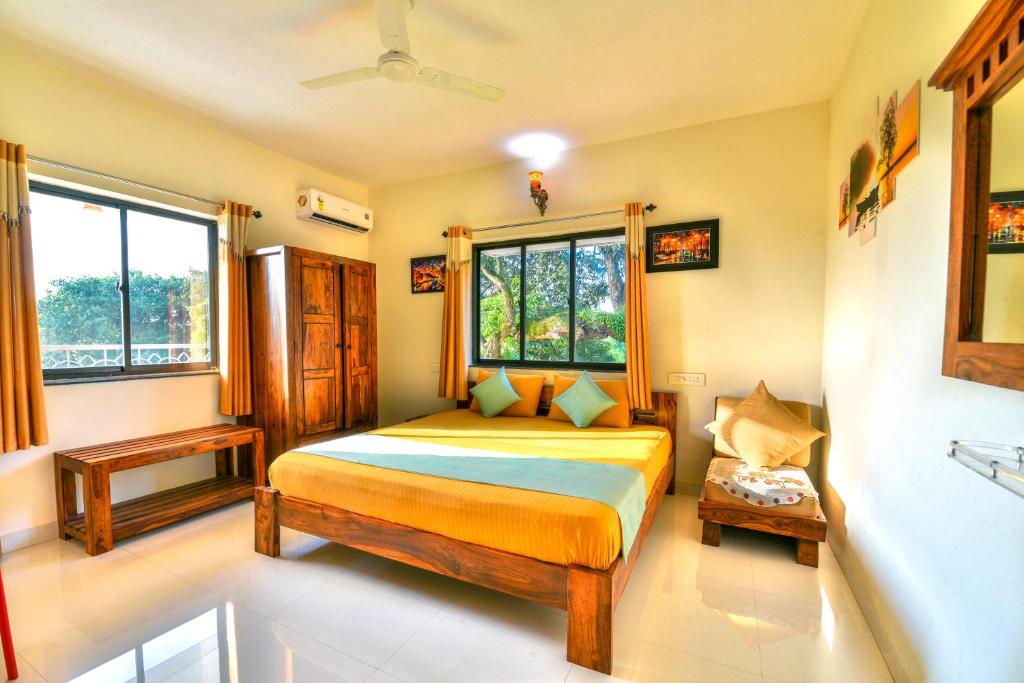 Un dormitorio con una cama y una ventana en Monarch Suites, en Candolim