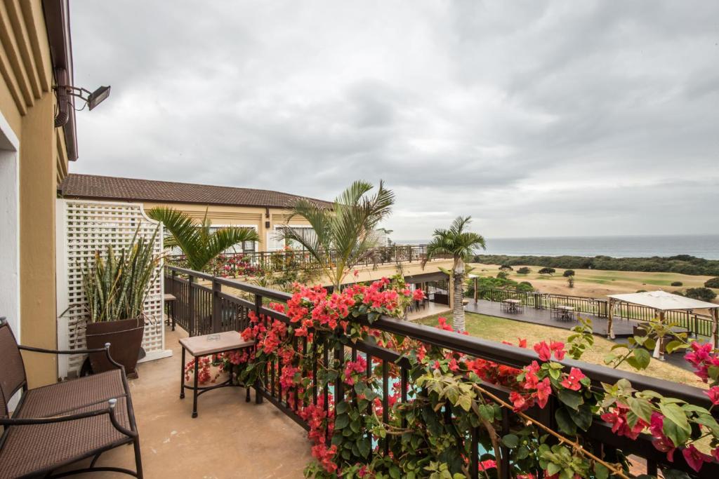 a balcony with flowers and a view of the ocean at Fairway Guest House in Durban