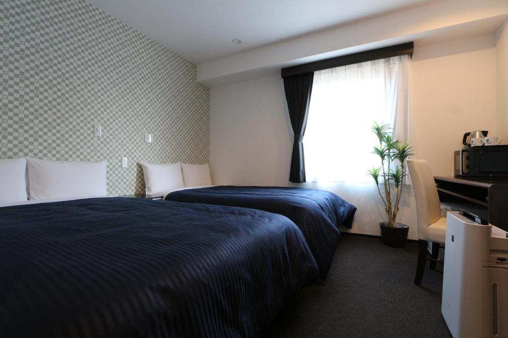Postel nebo postele na pokoji v ubytování HOTEL LiVEMAX Minamihashimoto Ekimae