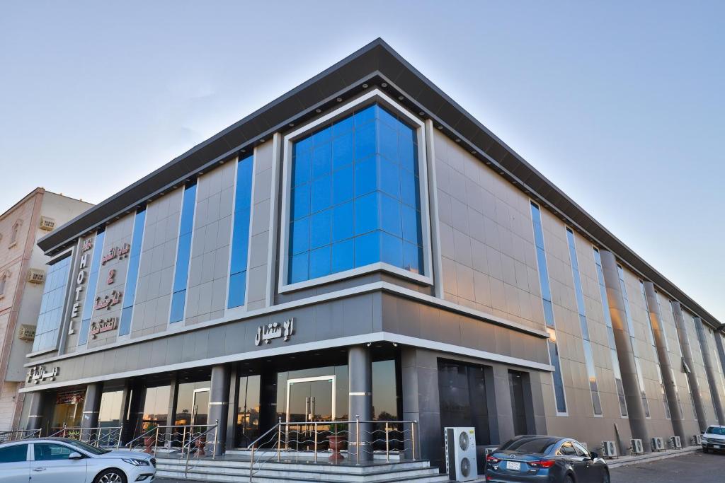 a large glass building with cars parked in front of it at Moon Gate 2 in Yanbu