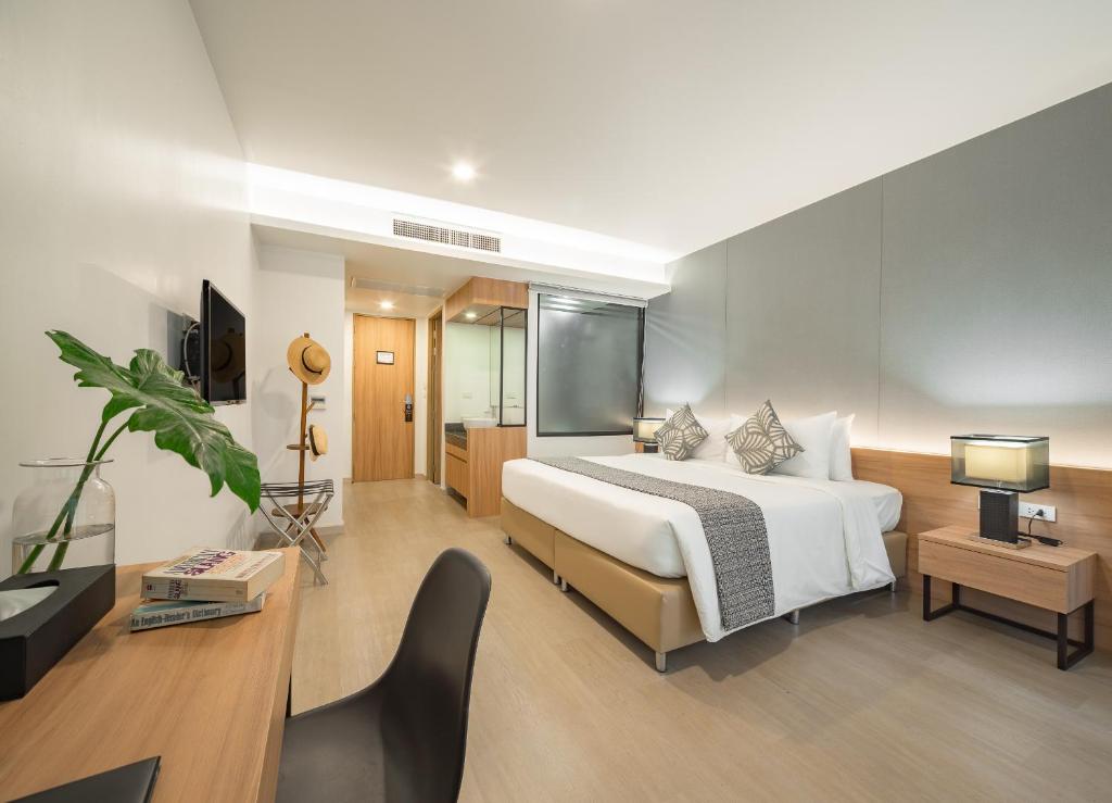 a bedroom with a bed and a desk and a tv at Nap in Chiangmai in Chiang Mai
