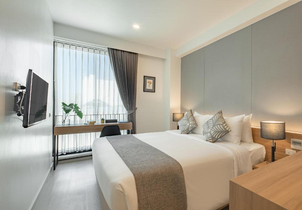 een hotelkamer met een groot bed en een televisie bij Nap in chiangmai in Chiang Mai