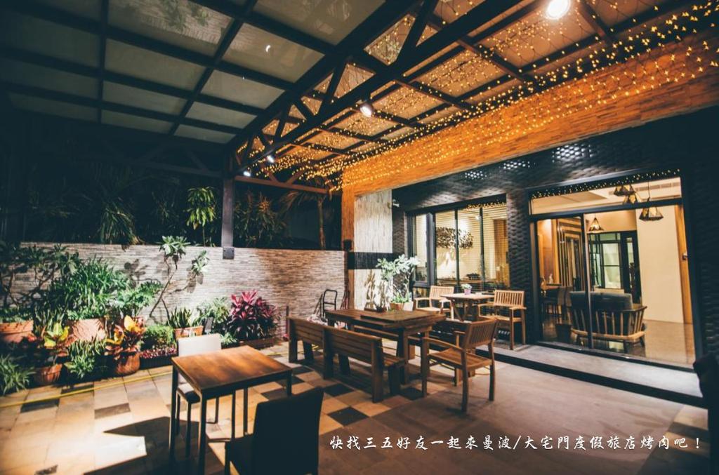 ein Restaurant mit Holztischen, Stühlen und Pflanzen in der Unterkunft Mambo Boutique Hotel in Altstadt von Hengchun
