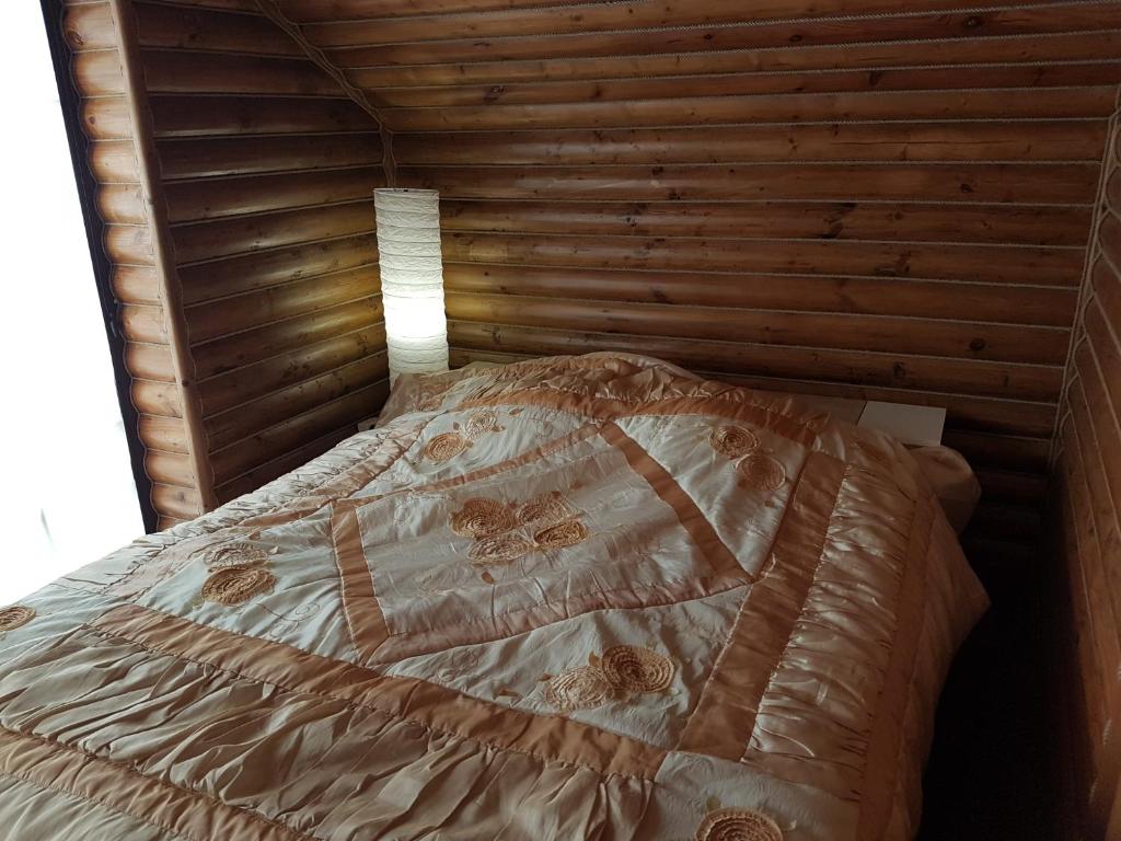a bed in a room with a wooden wall at Dom wakacyjny Różaniec in Różaniec