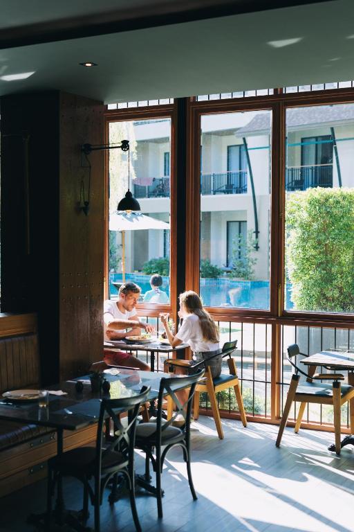 a group of people sitting at a table in a restaurant at Aurico Kata Resort & Spa - SHA Extra Plus in Kata Beach
