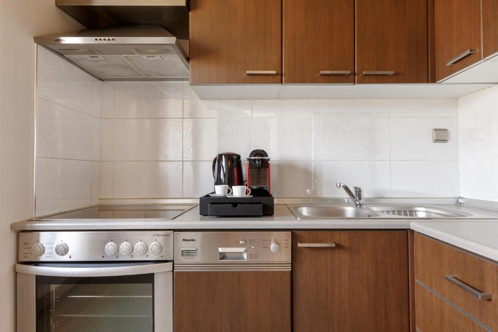 a kitchen with a sink and a stove at Melon Suites in Thessaloniki