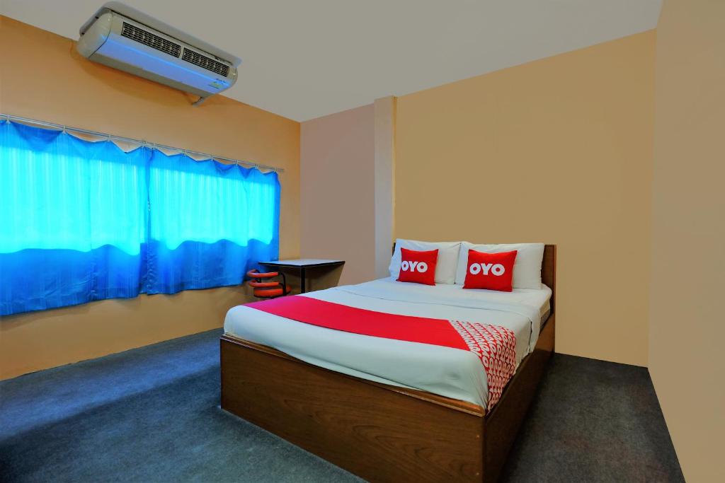 um quarto com uma cama com duas almofadas vermelhas em OYO 588 Rose In Mansion em Trang