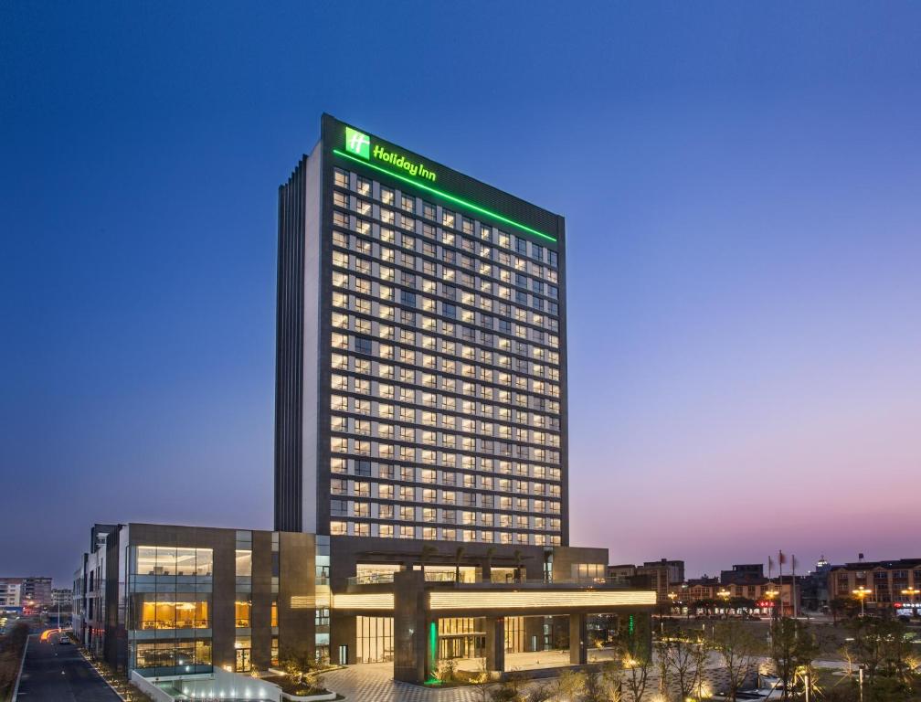 a tall building with a green sign on it at Holiday Inn Putian Xiuyu, an IHG Hotel in Putian