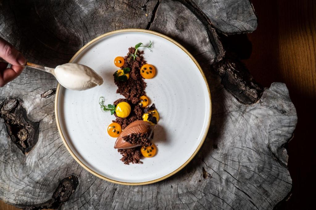 a plate of food on a table with a spoon at Walliserhof Grand-Hotel & Spa Relais & Châteaux in Saas-Fee