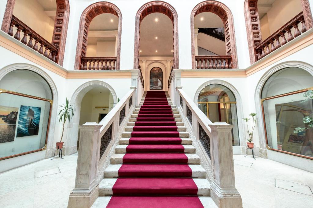a staircase in a building with a pink carpet at Luxury Loft next to Saint Mark in Venice