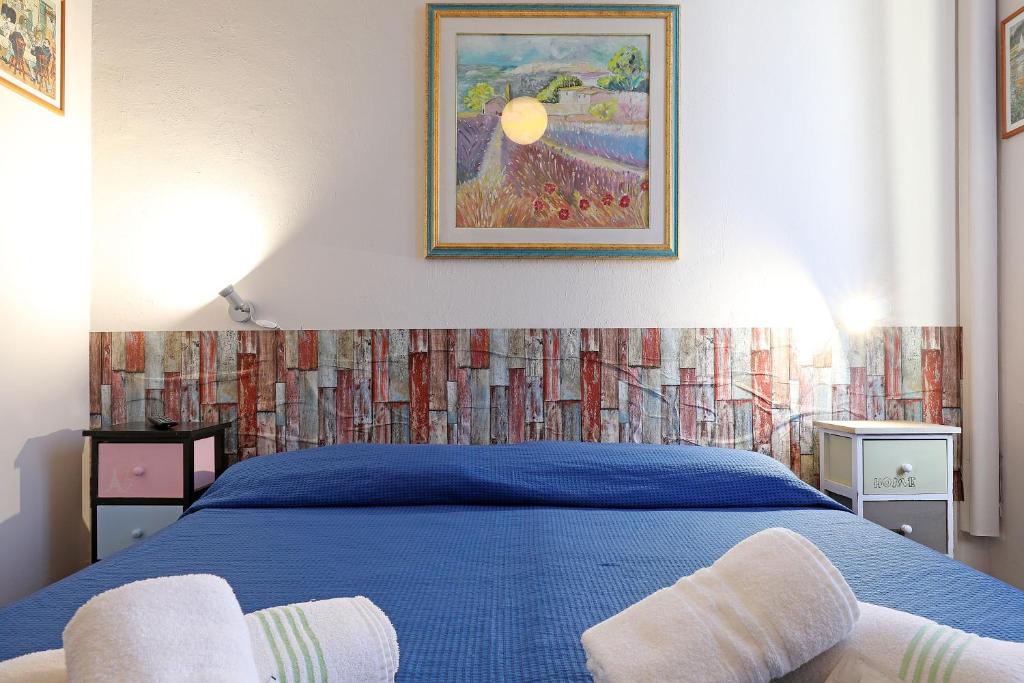 a bedroom with a blue bed with two towels on it at casa ros via ostiense 73 in Rome