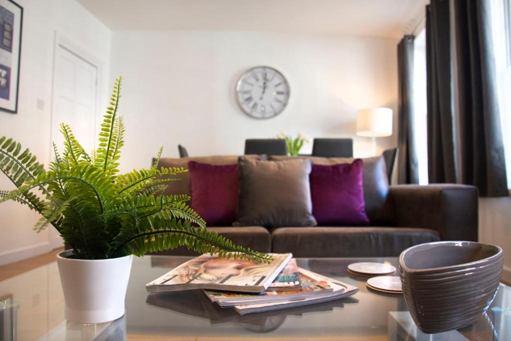 a living room with a couch and a table with a plant at Flower In Hand Apartment in Norwich
