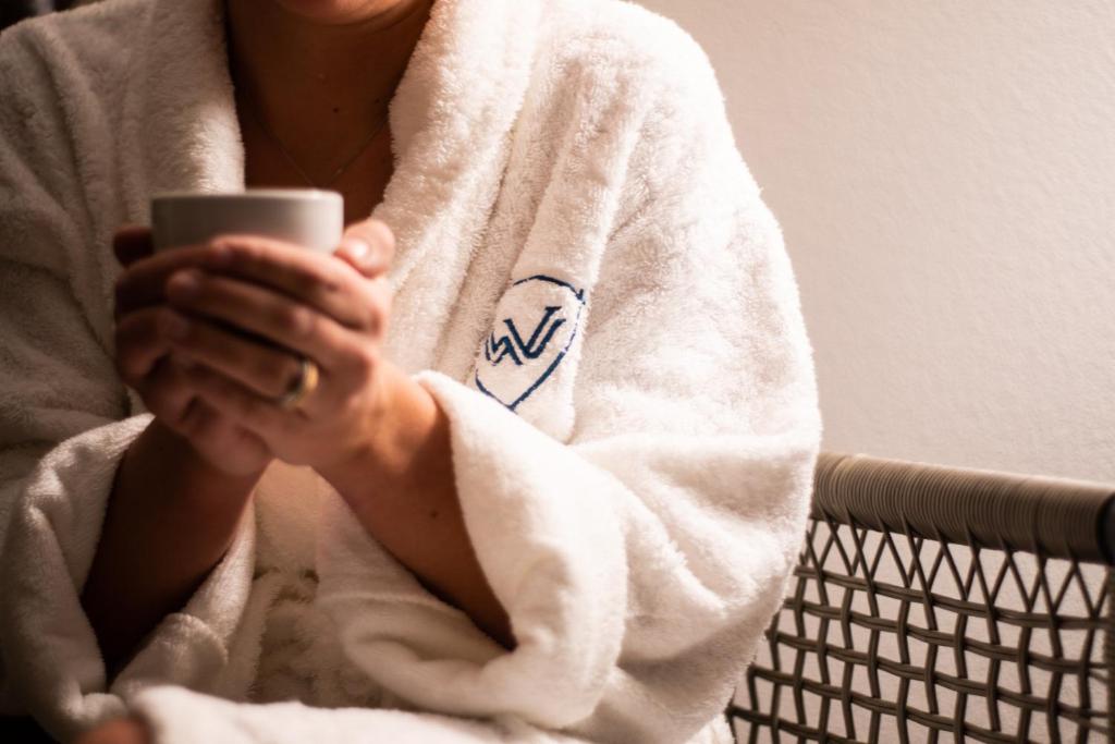 a woman in a towel holding a cell phone at Walliserhof Grand-Hotel & Spa Relais & Châteaux in Saas-Fee