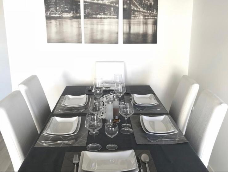 イヴリー・シュル・セーヌにあるBeautiful 3 bedroom flat 8-9 personsのダイニングルームテーブル(黒いテーブル、白い椅子付)