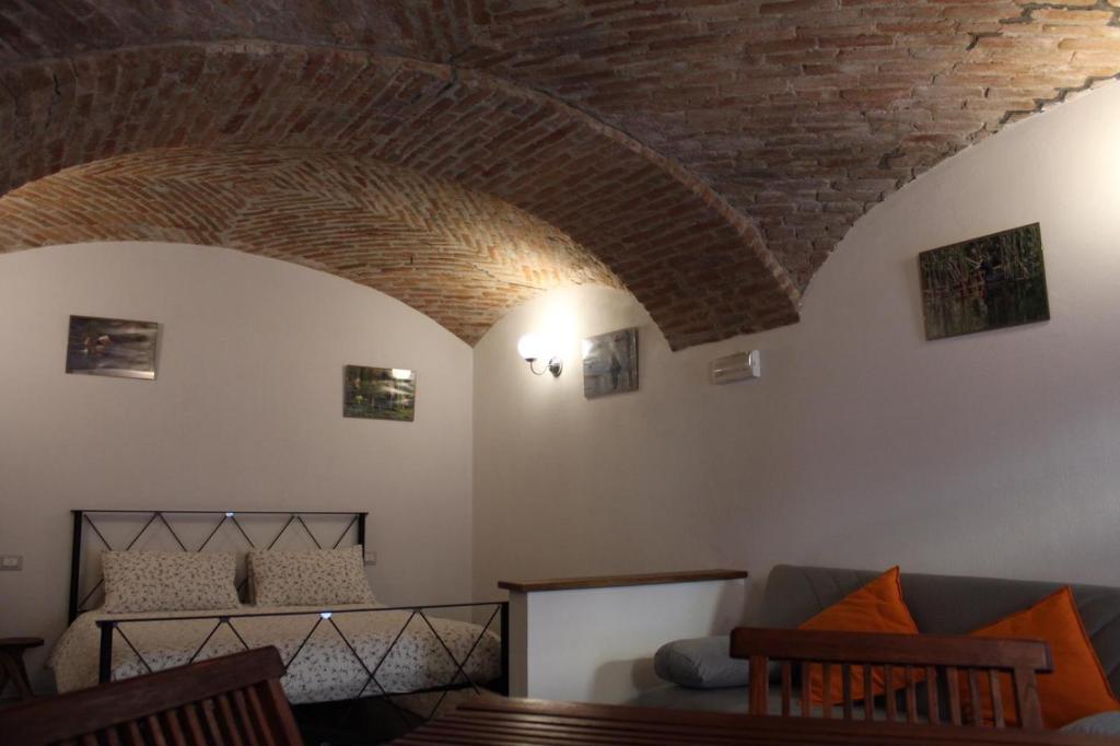 a living room with a couch and a brick ceiling at Bed&Braja in Vische