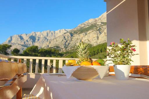 een fruitschaal op een tafel op een balkon bij Villa Natasha in Makarska