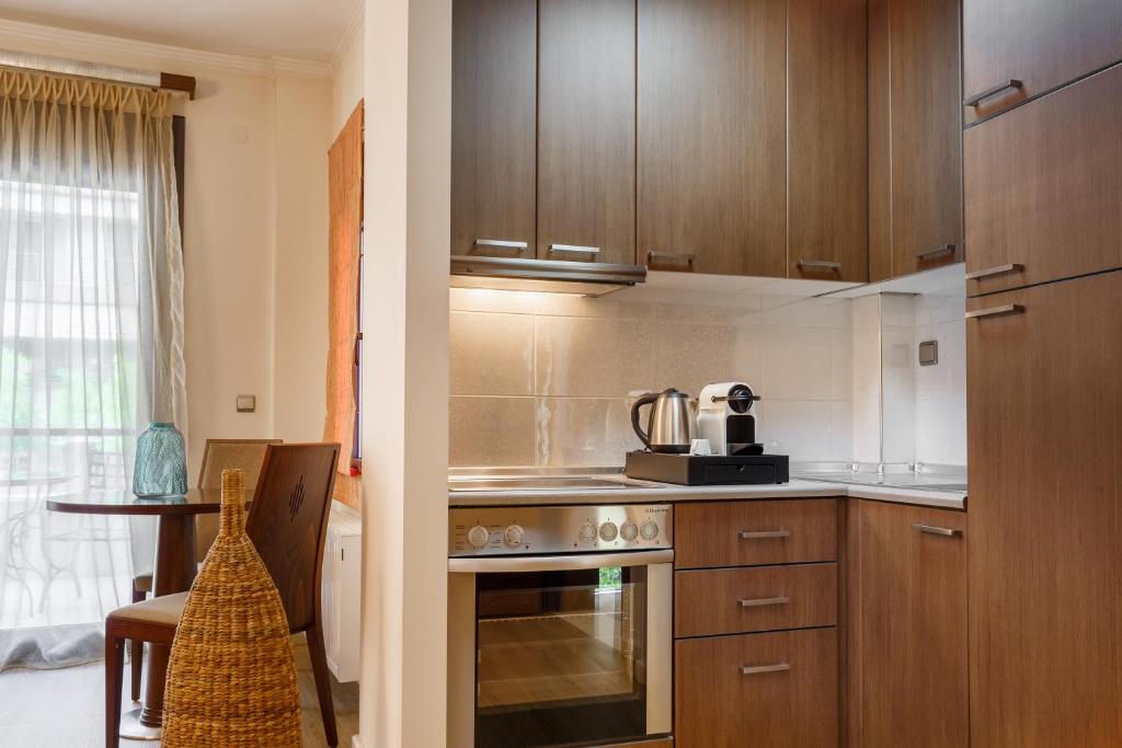 a kitchen with wooden cabinets and a stove top oven at Melon Suites in Thessaloniki