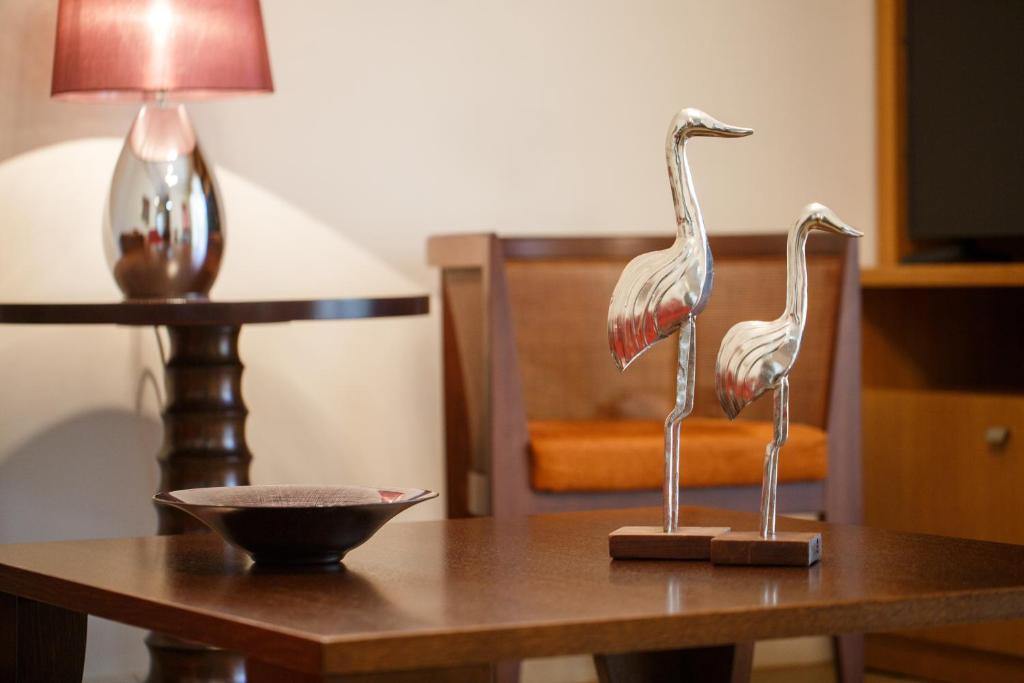 two statues of flamingos on a wooden table at Melon Suites in Thessaloniki