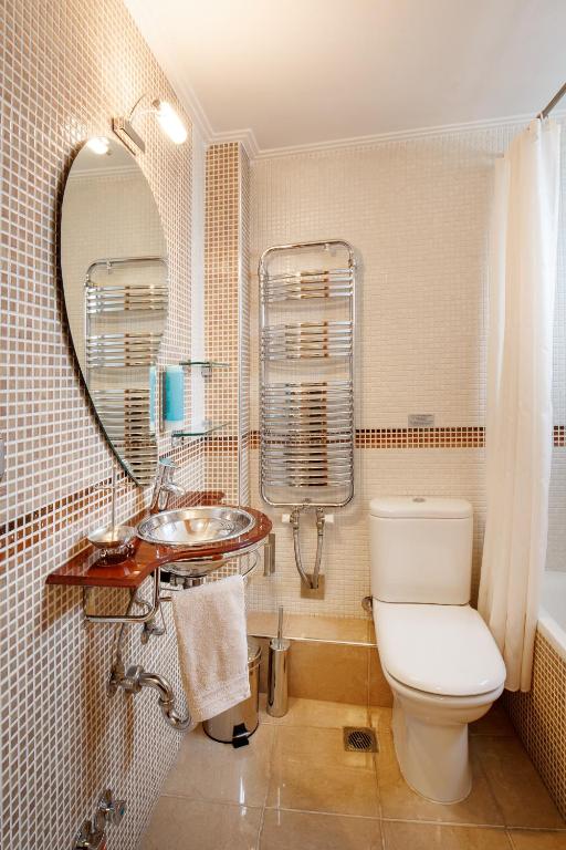 a bathroom with a toilet and a sink and a mirror at Melon Suites in Thessaloniki