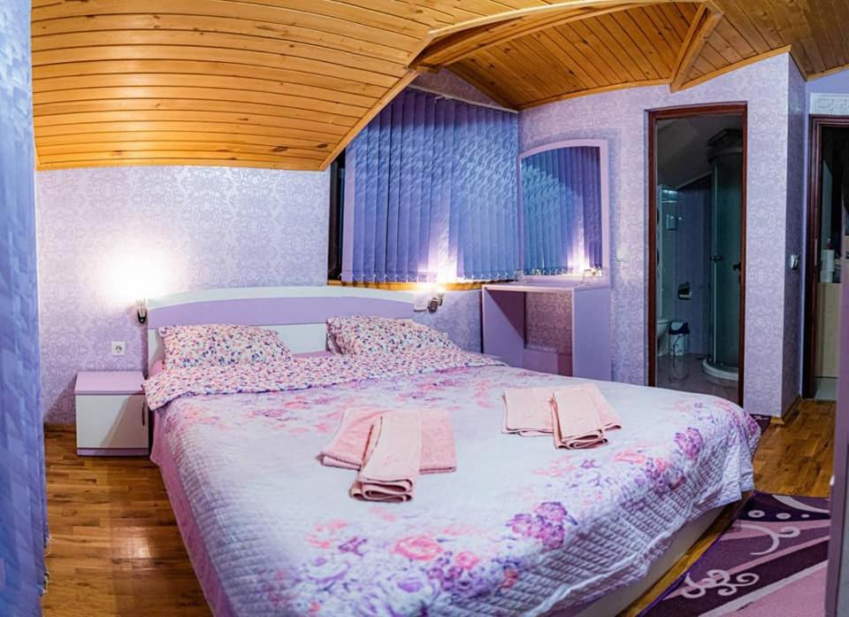 a bedroom with a large bed with towels on it at Stanchevata Kashta in Zlatograd