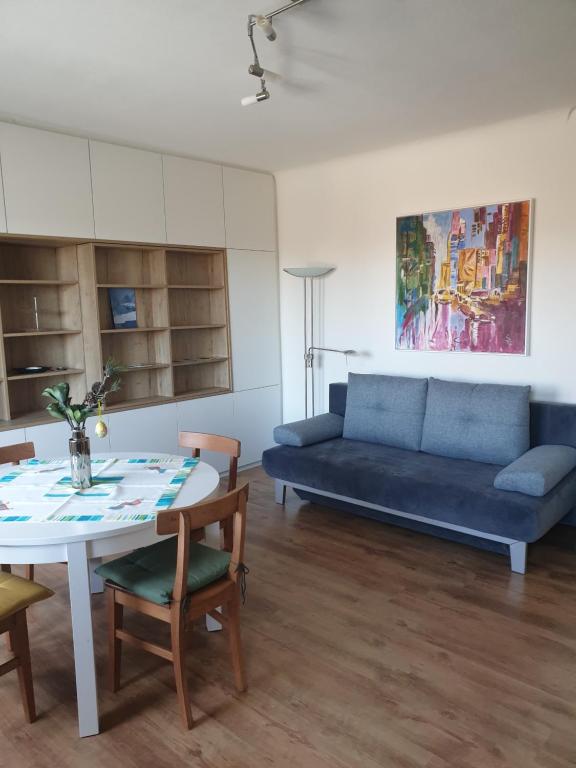 ein Wohnzimmer mit einem blauen Sofa und einem Tisch in der Unterkunft Apartment Stockerau in Stockerau
