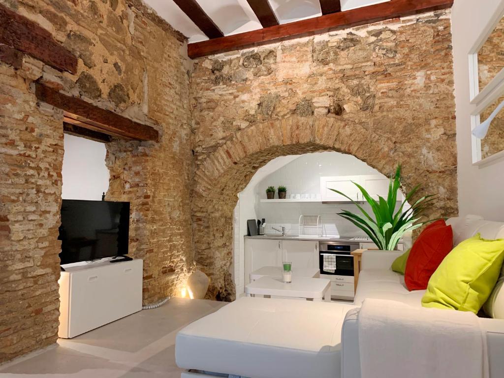 a living room with a white couch and a brick wall at Apto Toledo Medieval - Parking Gratis in Toledo