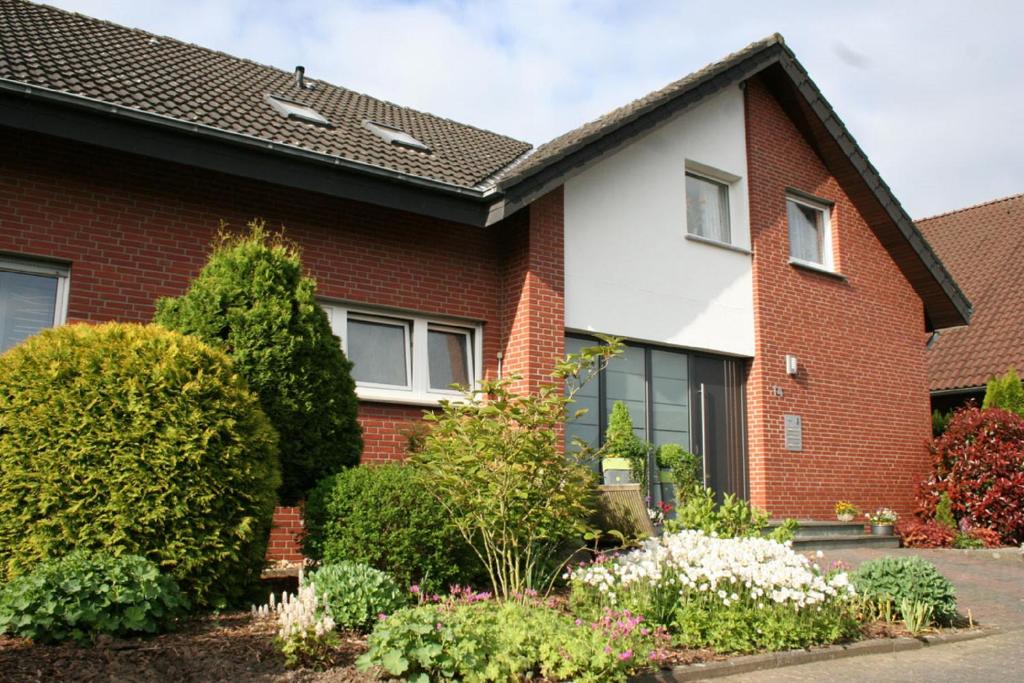 una casa de ladrillo rojo con arbustos en Ferienwohnungen Lohner Höhe, en Bad Sassendorf