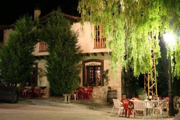 una mesa y sillas frente a una casa en Hotel Rural Pantano de Burgomillodo, en Burgomillodo