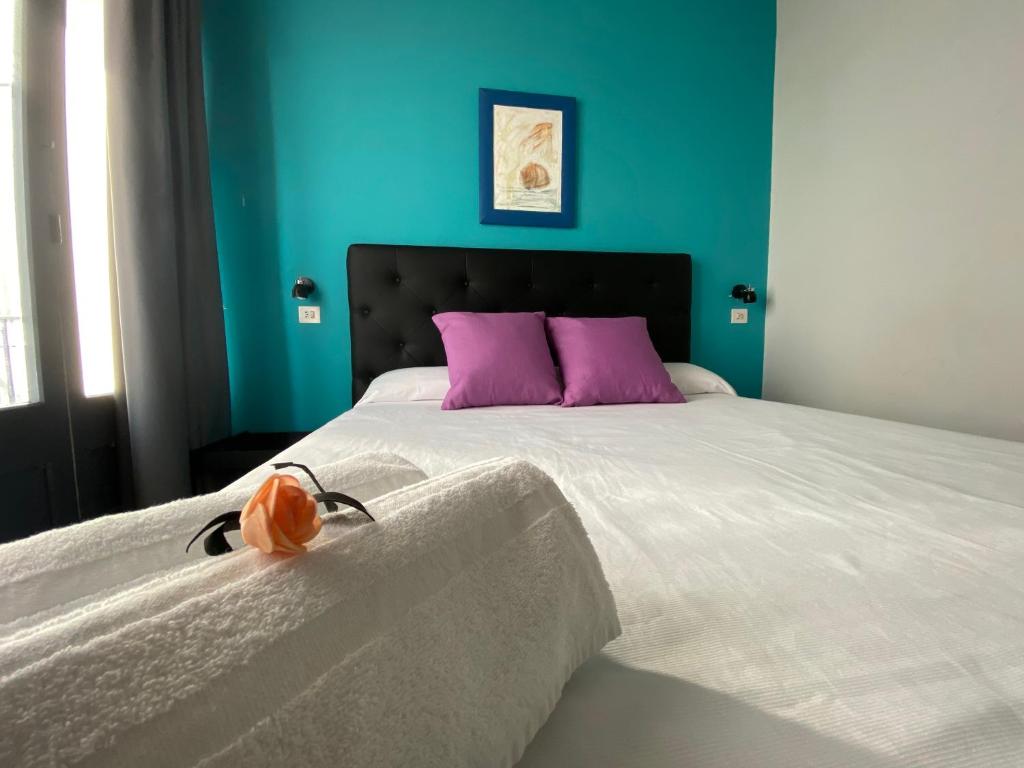 a bedroom with a large bed with purple pillows at Agi Macià Centro in Roses