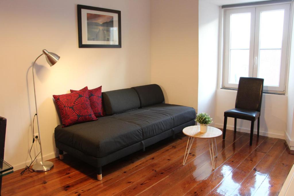 sala de estar con sofá negro y mesa en Lisbon Apartment, en Lisboa