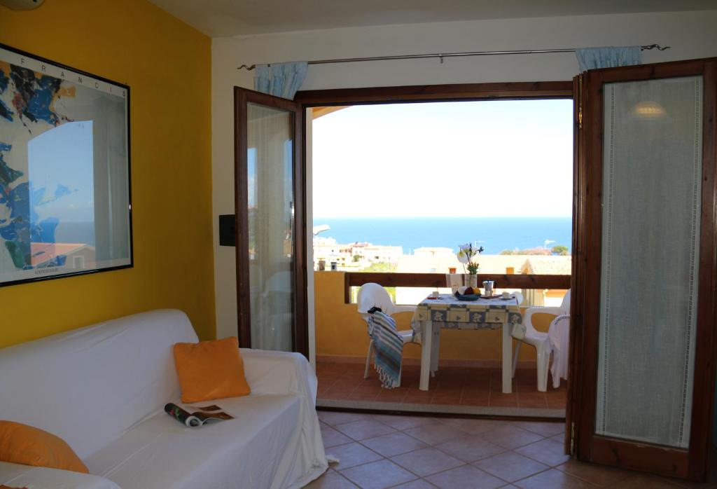 - un salon avec un canapé blanc et une table dans l'établissement SARDINIA RE - Casa La Spiga, à Castelsardo