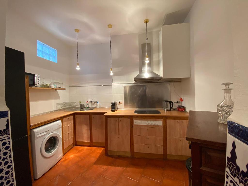 a kitchen with a sink and a washing machine at Casa del Conde in Málaga