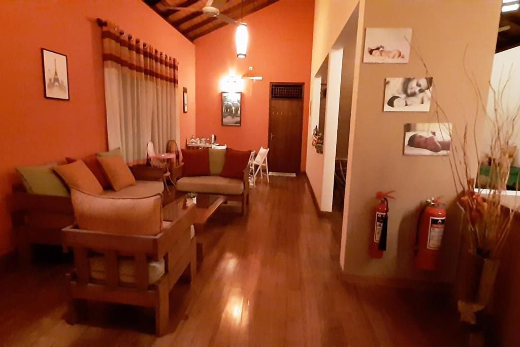 - un salon avec des murs orange et du parquet dans l'établissement Greenro Residence Colombo, à Kottawa