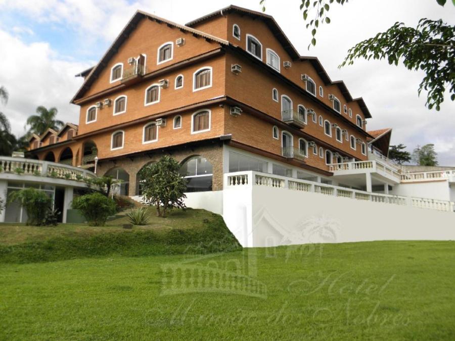 a large building with a green lawn in front of it at Hotel Mansão dos Nobres in São João da Boa Vista