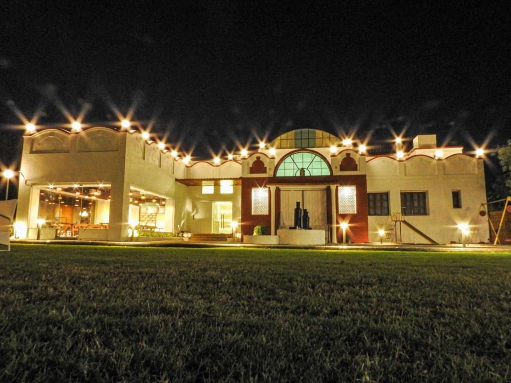 un grand bâtiment avec des lumières allumées la nuit dans l'établissement Casa Blanca - A Boutique Resort, à Ahmedabad