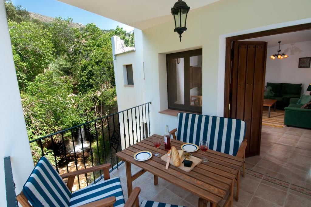 d'une terrasse avec une table et des chaises en bois sur un balcon. dans l'établissement El Granero at Molino la Ratonera, à Zagra