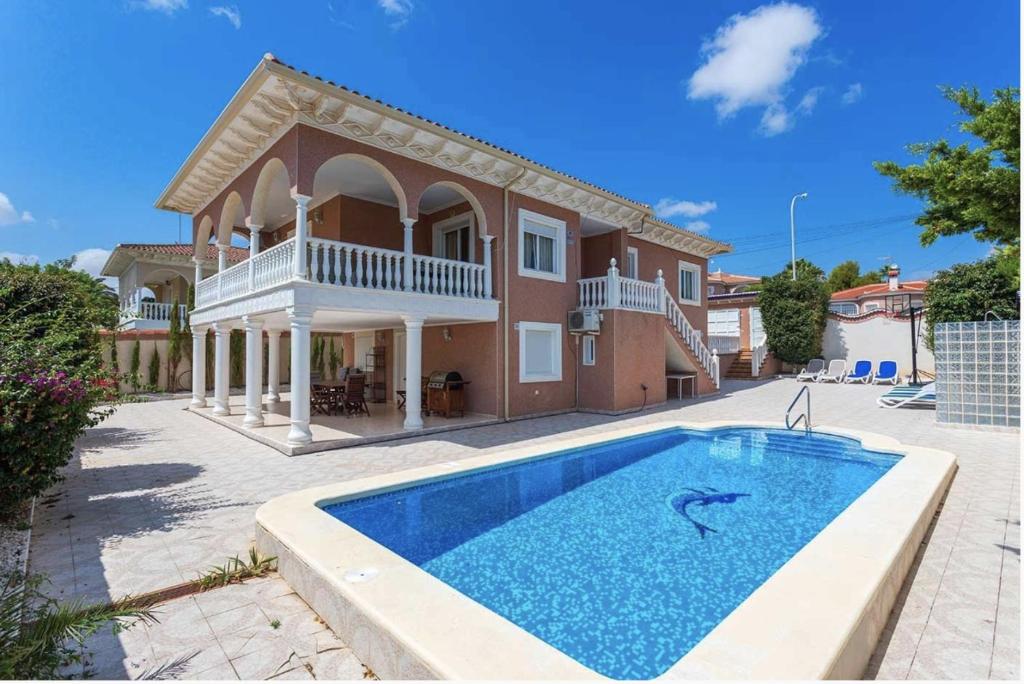 a villa with a swimming pool in front of a house at Villa SunShine Ciudad Quesada Spain in Ciudad Quesada