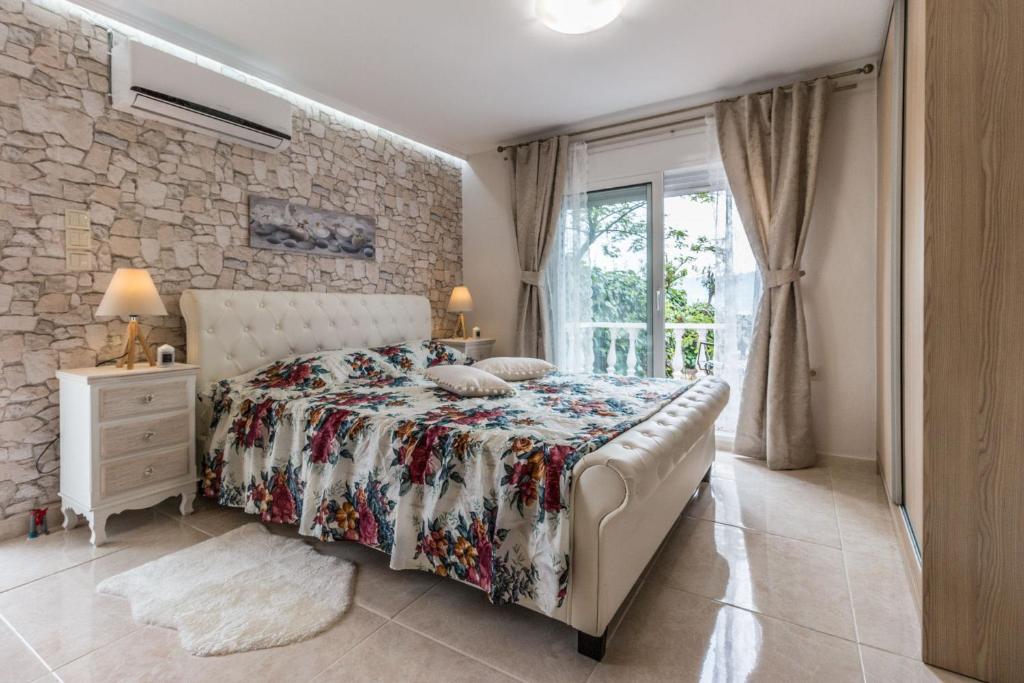 - une chambre avec un lit et un mur en pierre dans l'établissement Anastasia Residence Sea View, à Vólos