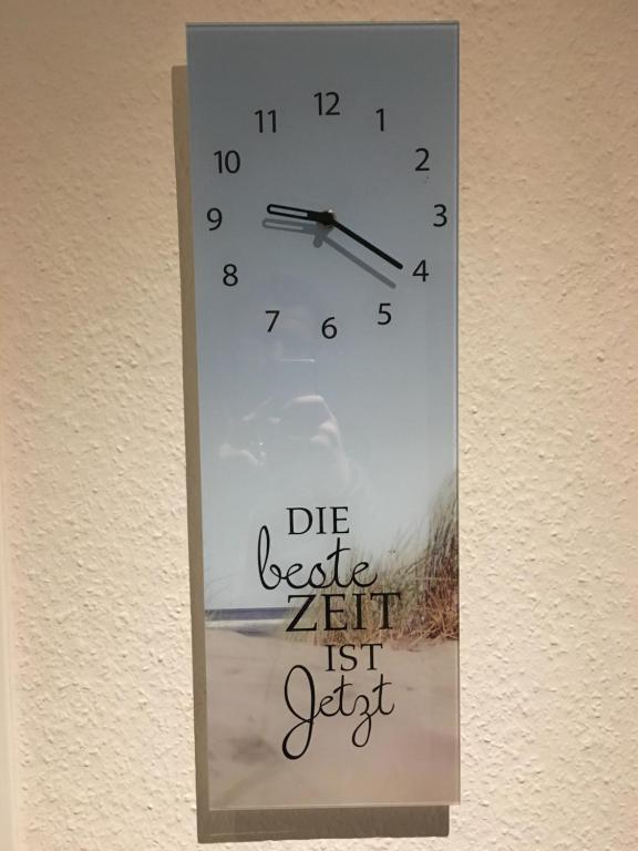 Un orologio appeso a un muro con le parole "muori ago ancora". di Messe zu Fuß ad Hannover