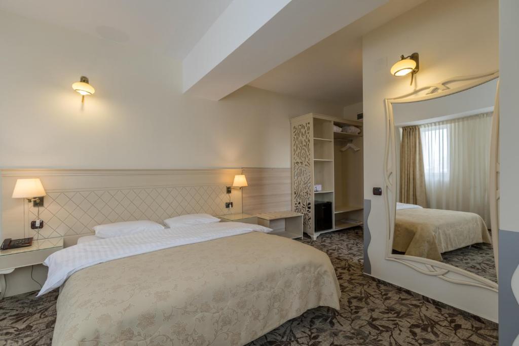 sypialnia z dużym łóżkiem i dużym lustrem w obiekcie Casa Siqua w Bukareszcie