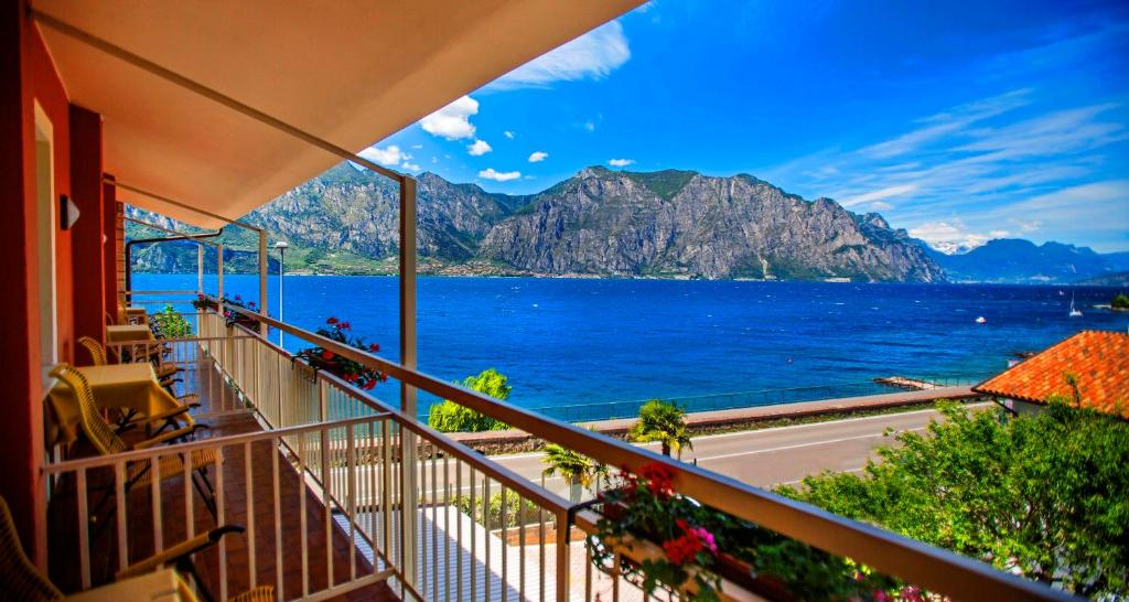 een balkon met uitzicht op het water en de bergen bij Hotel Al Molino in Malcesine