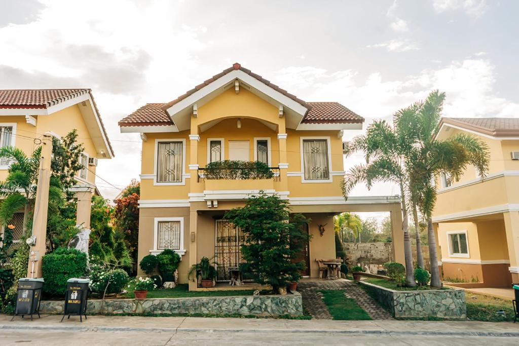 een geel huis met bomen ervoor bij Perfect staycation for families, friends, business travelers and tourist in Calacapan