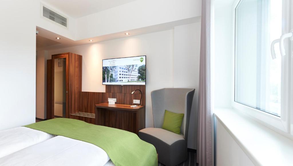 - une chambre avec un lit, une chaise et une fenêtre dans l'établissement numberOne Hotel, à Nuremberg